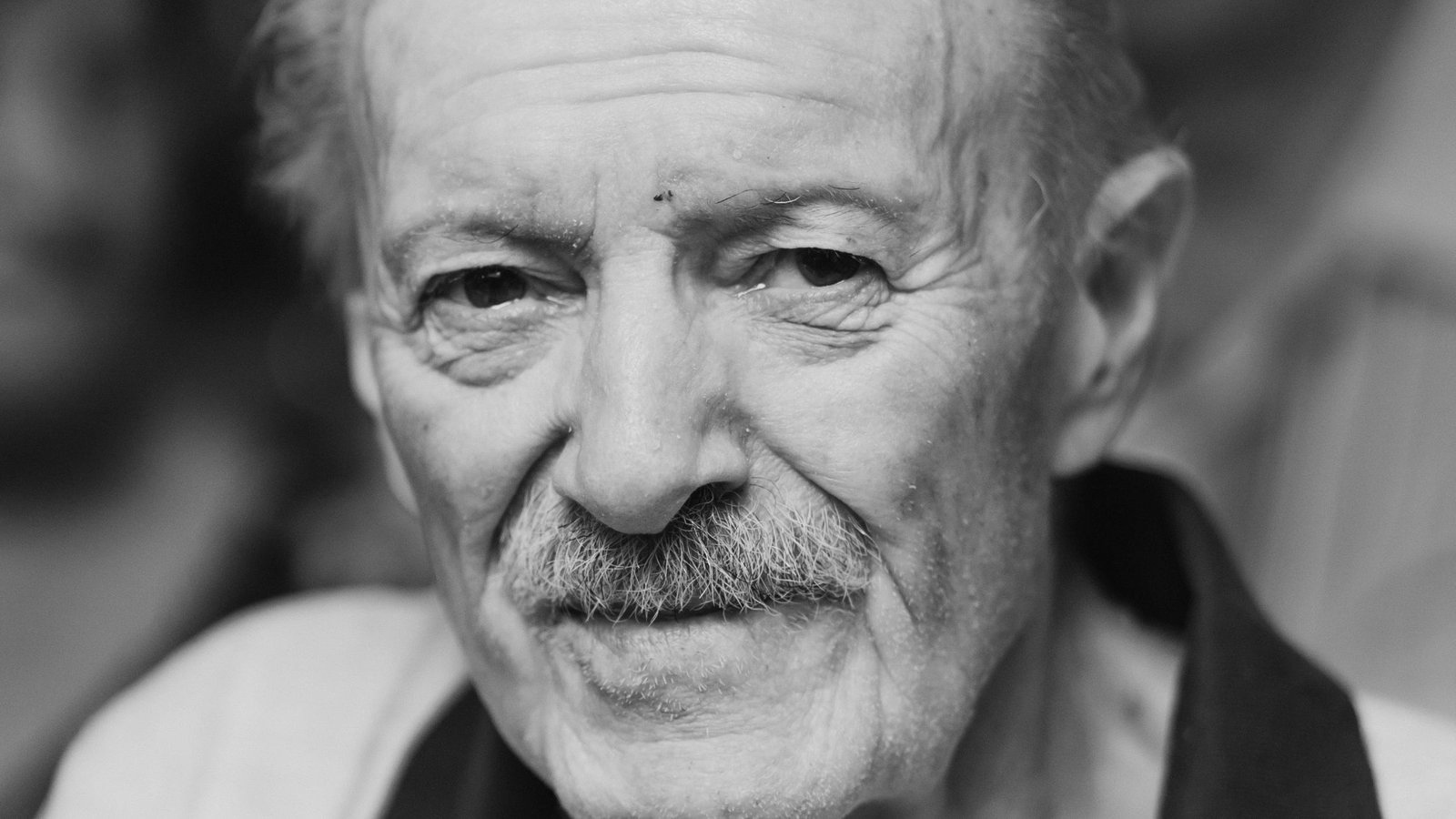 Portrait en noir et blanc d'un grand-père au regard doux, séance photo aînés en Auvergne