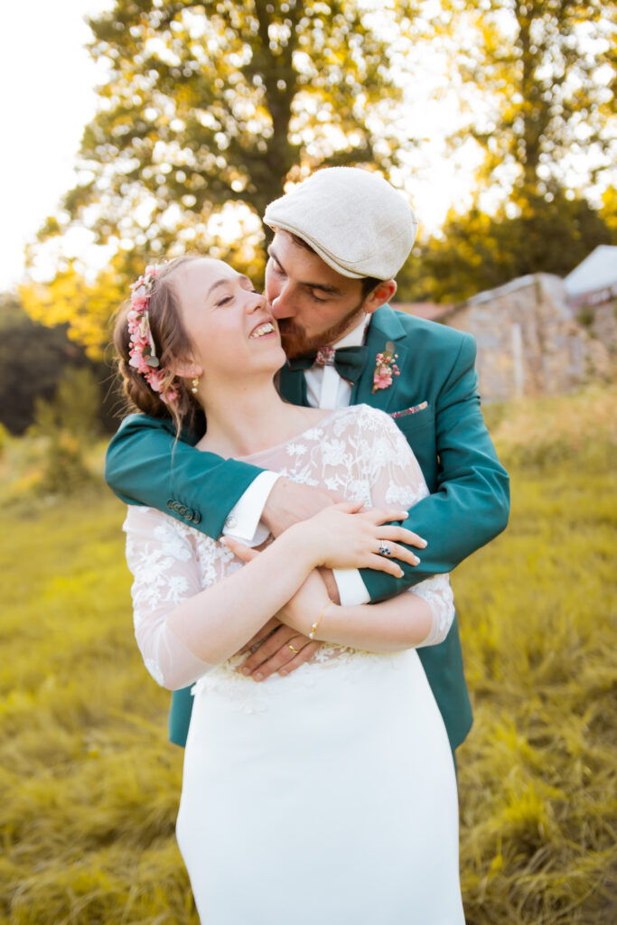 Couple de mariés qui s'embrassent au coucher du soleil