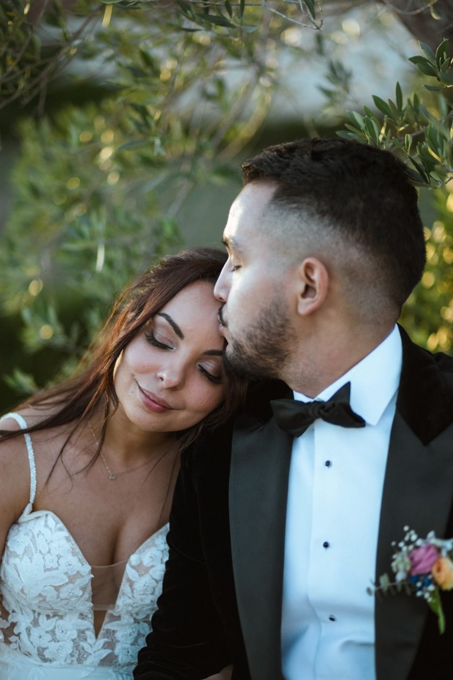 Le marié embrasse le front de la mariée le jour du mariage