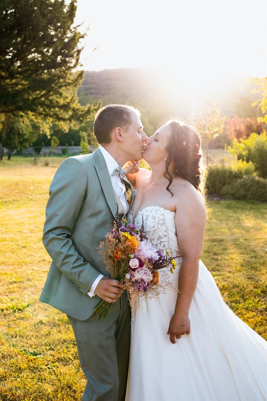 Baiser des mariés au coucher du soleil, mariage dans un château en Auvergne