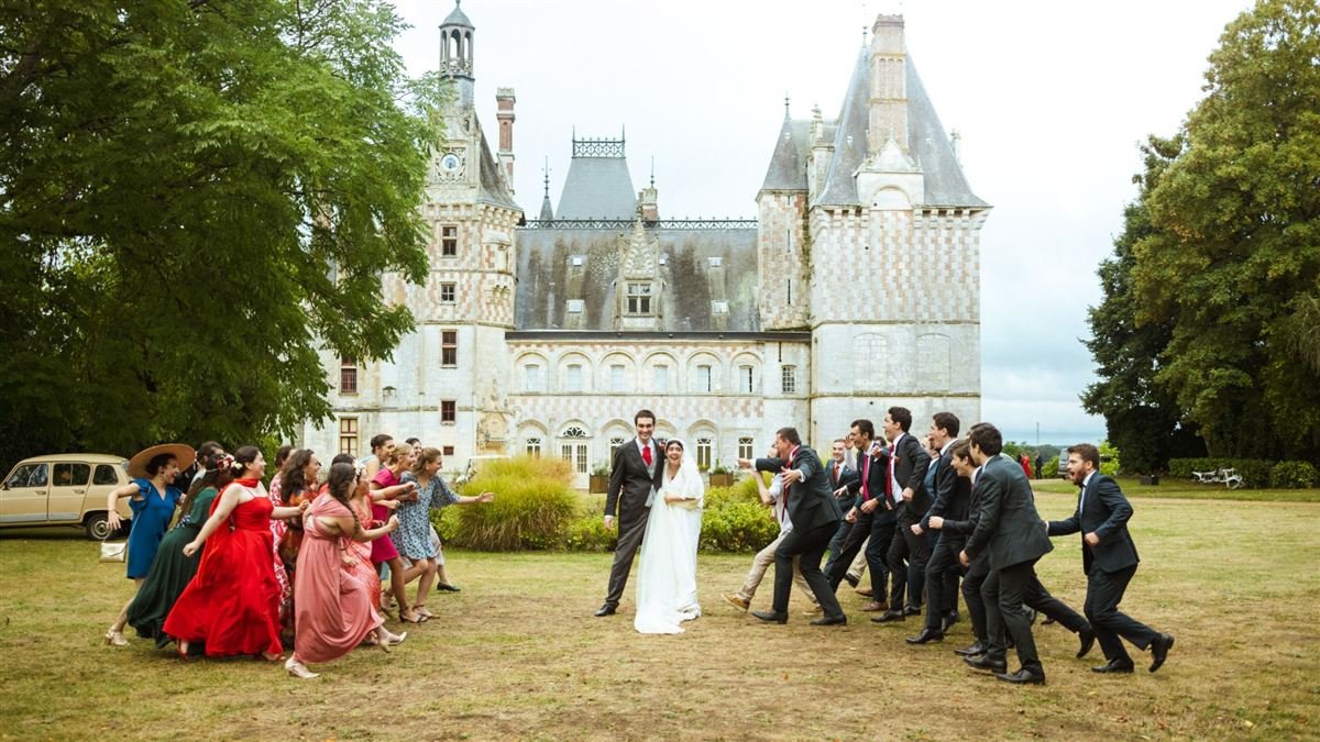 Mariage au château : les invités courent en riant vers les jeunes mariés