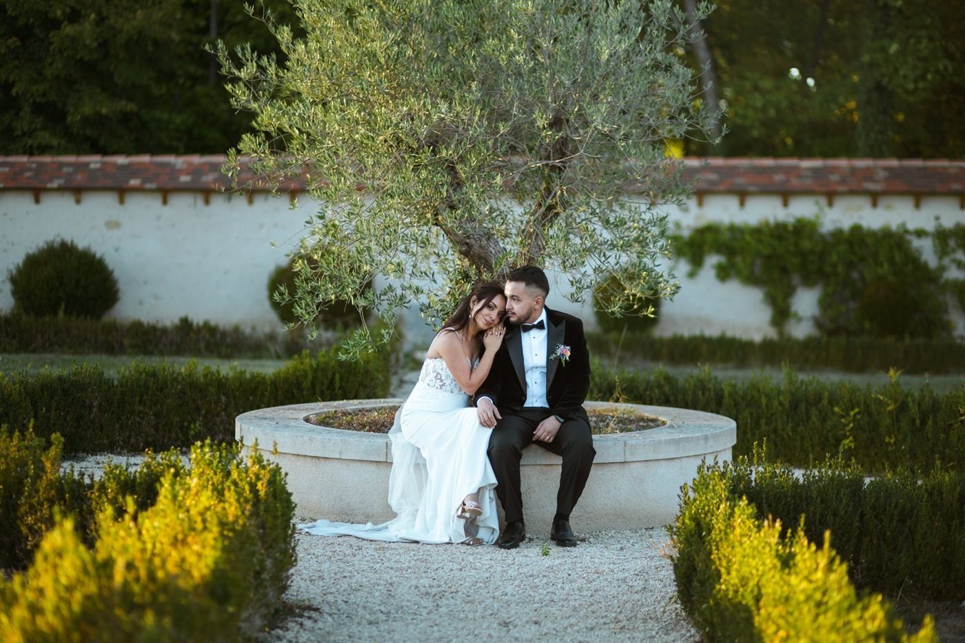 Les mariés assis sous un olivier dans un jardin à la française, mariage près de Clermont-Ferrand