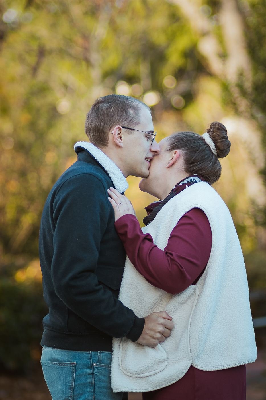Baiser des futurs mariés dans la lumière dorée d'automne en séance engagement