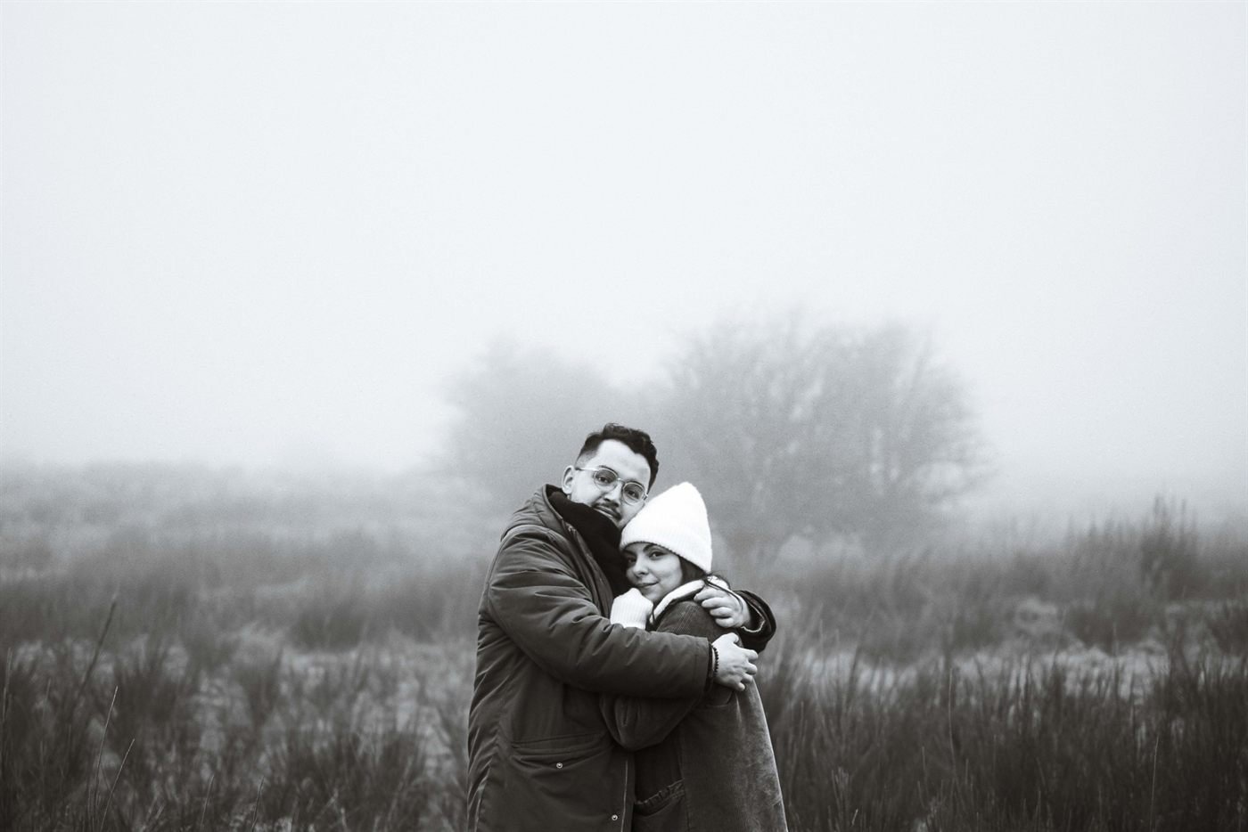 Câlin en noir et blanc des fiancés qui regardent l'objectif, séance engagement en Auvergne