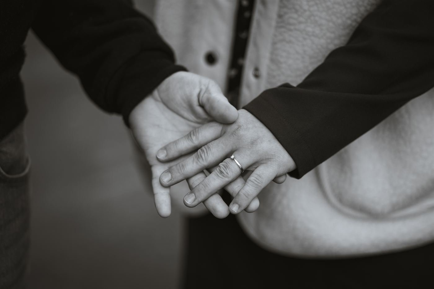 Mains et bague de fiançailles en noir et blanc lors d'une séance engagement